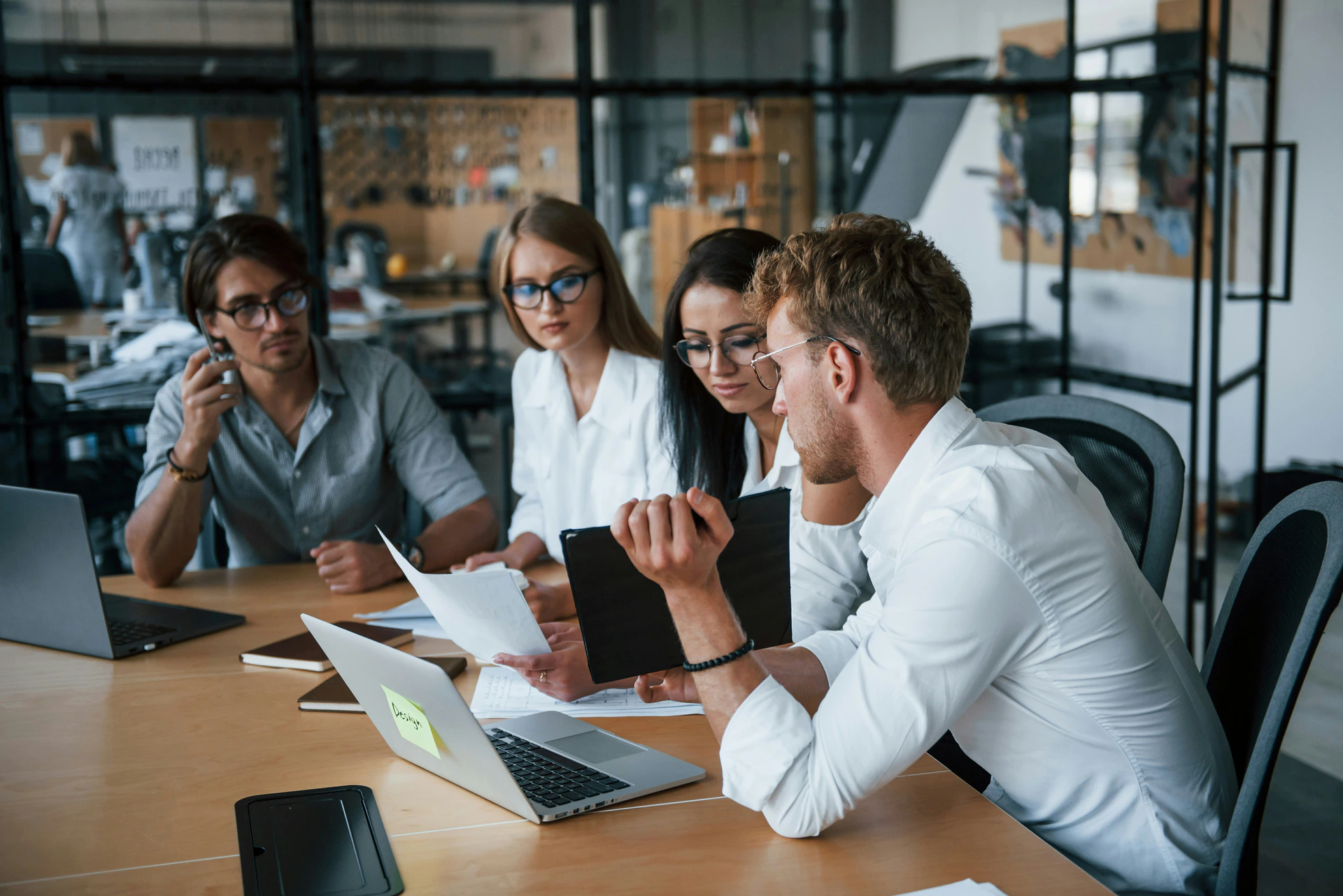 A team reviewing work together at a desk in a modern office - the workplace CHIRAYOU is built for.